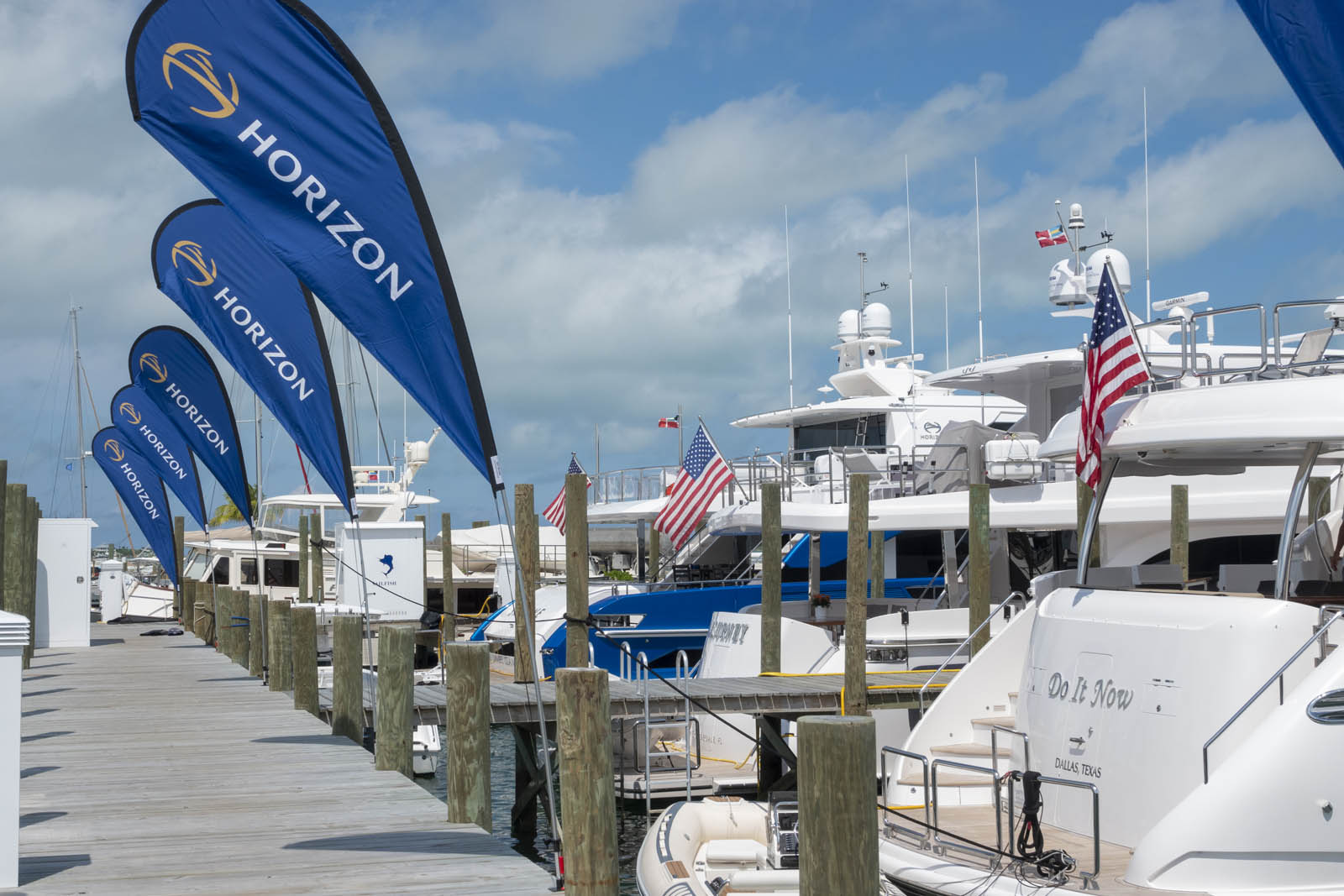 Horizon Yachts Rendezvous main dock with flags flying in front of yachts.